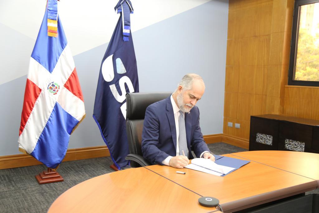 Superintendente de Bancos firmando documentos